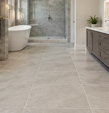 Pale ceramic floor tiles with a glass shower and bathtub